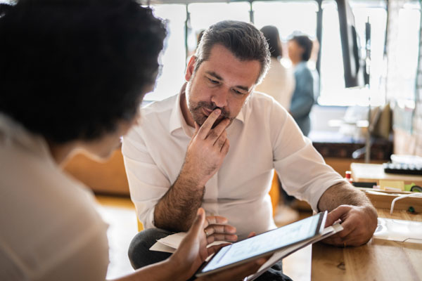 man and woman looking at tablet screen