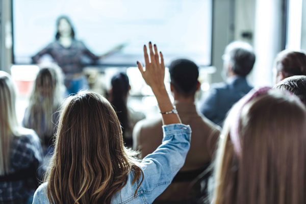 woman raising hand at a meeting