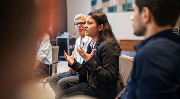 woman speaking and gesturing at a meeting